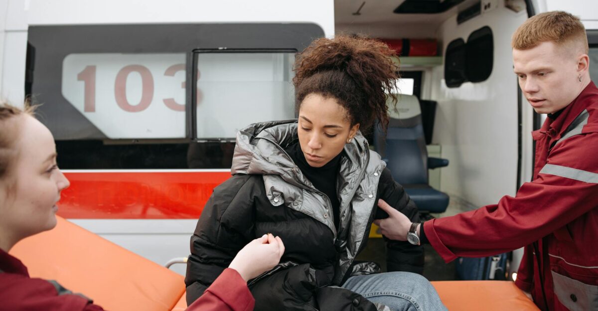 Paramedics provide assistance to a woman by an ambulance conveying concern and urgency