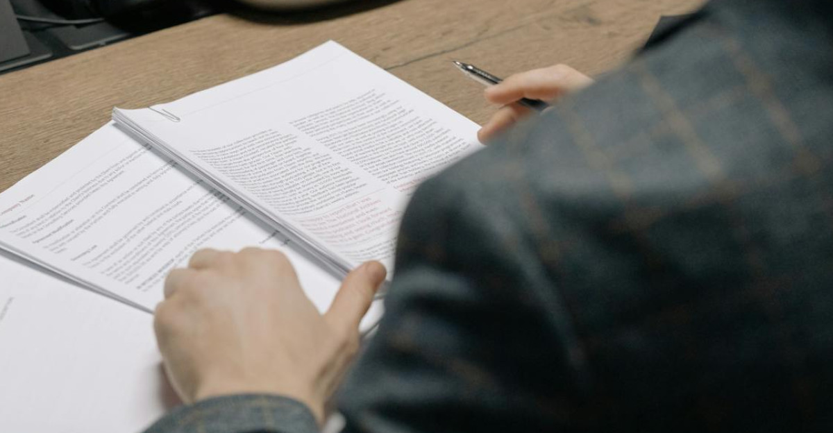 Close-up of business professionals reviewing documents during a meeting in a modern office setting