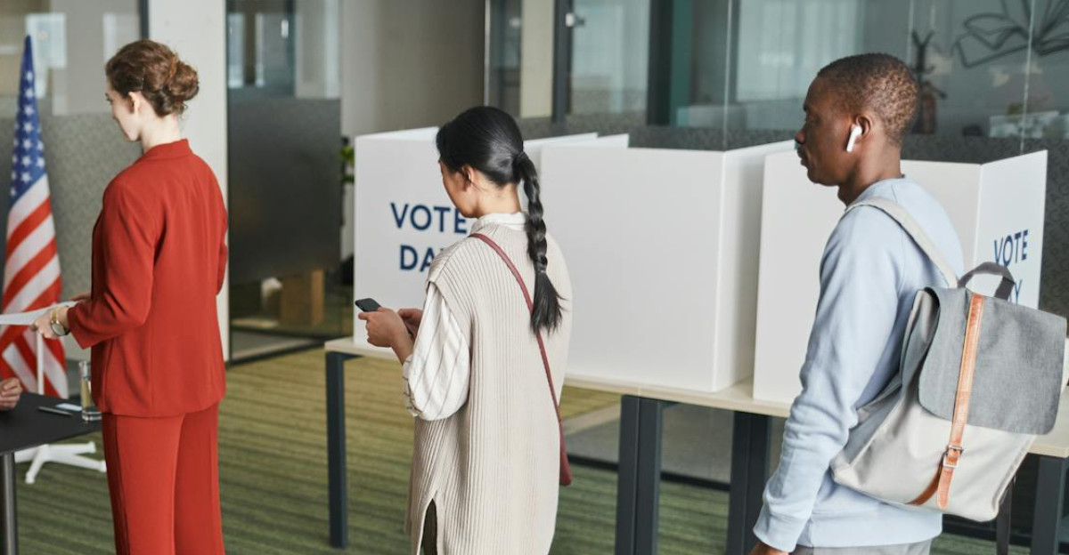 Diverse group of voters lining up at an indoor polling station on election day