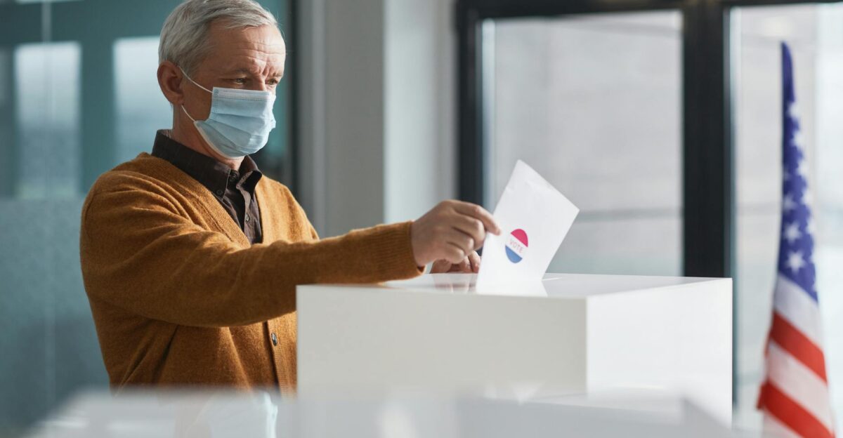 An elderly man wearing a face mask votes in-person highlighting safety during the pandemic