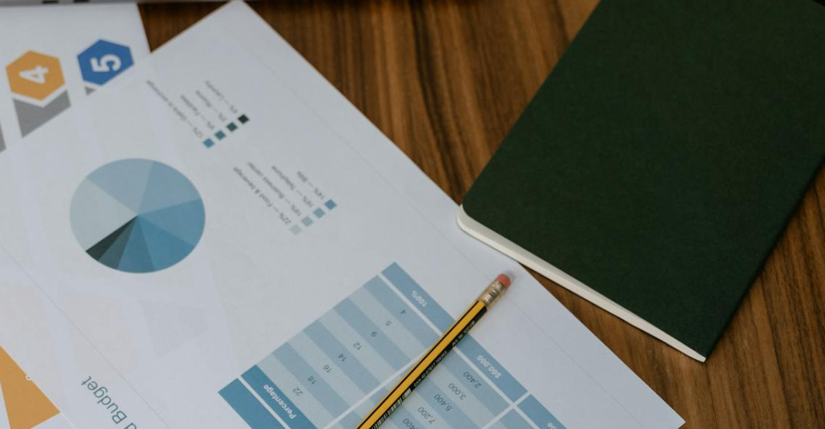Overhead view of project management documents and charts on a desk with a pencil