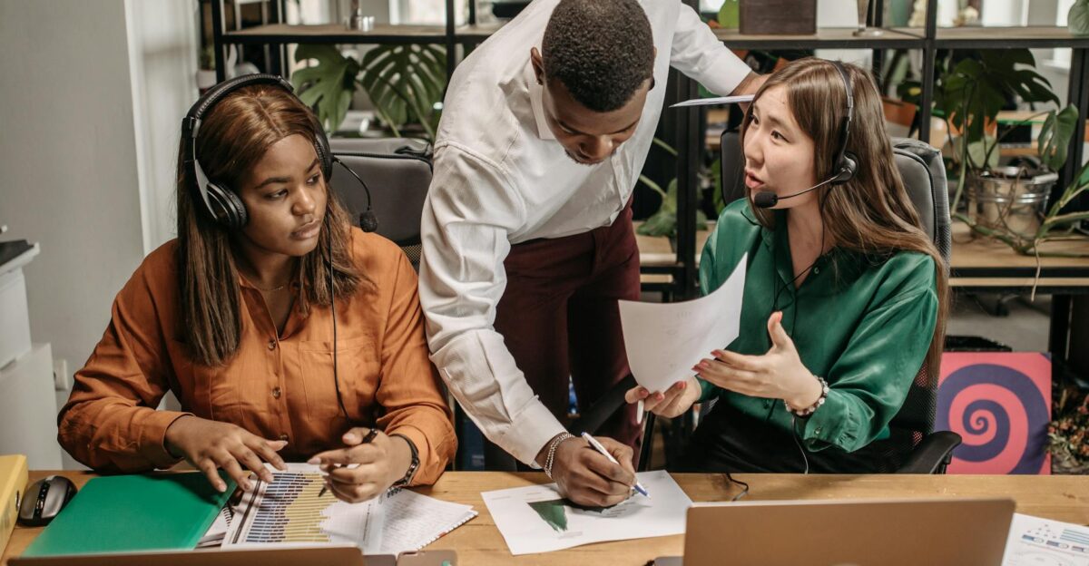Diverse team collaborating in an office setting with technology and reports