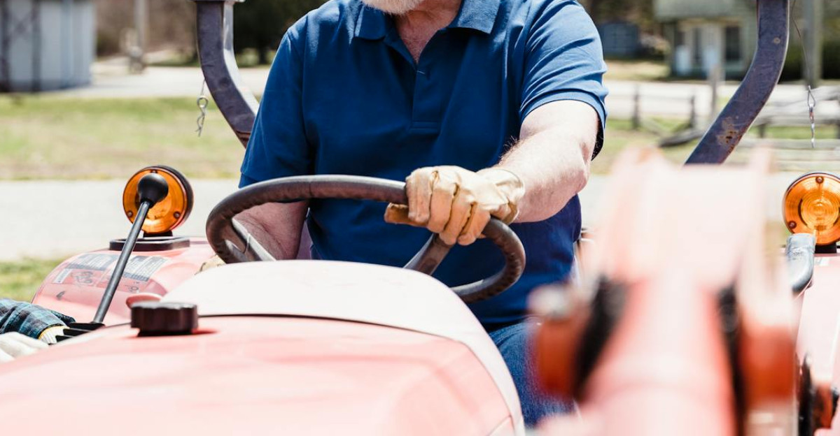 A man and woman operating a tractor on a farm capturing a rural lifestyle