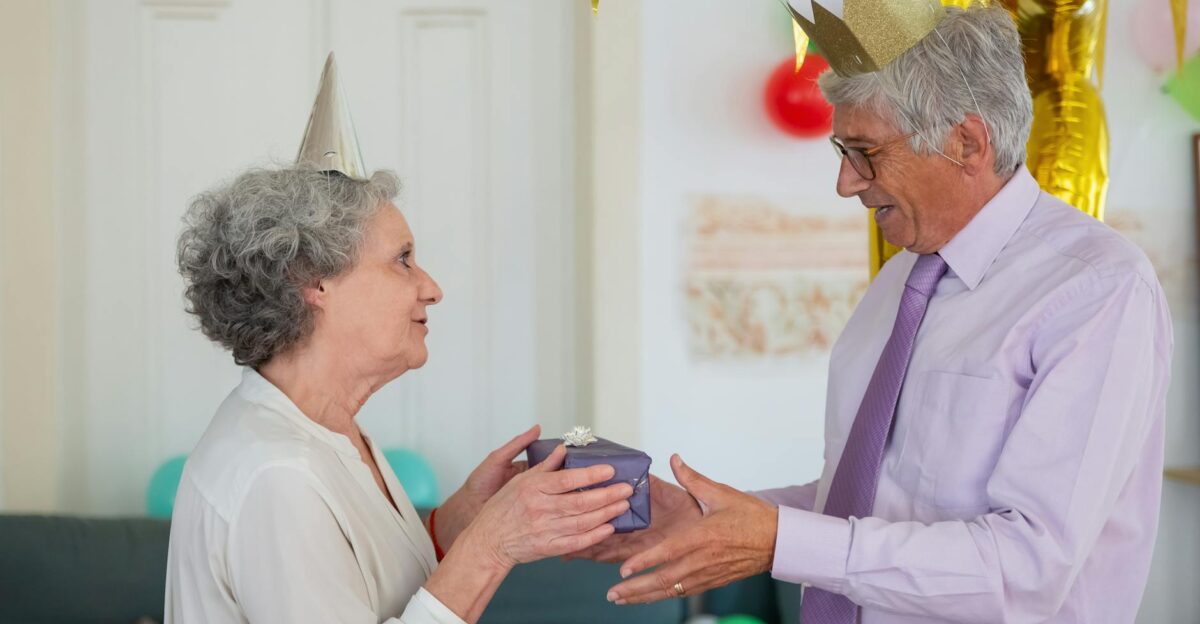 Happy senior couple exchanging gifts during a birthday celebration at home