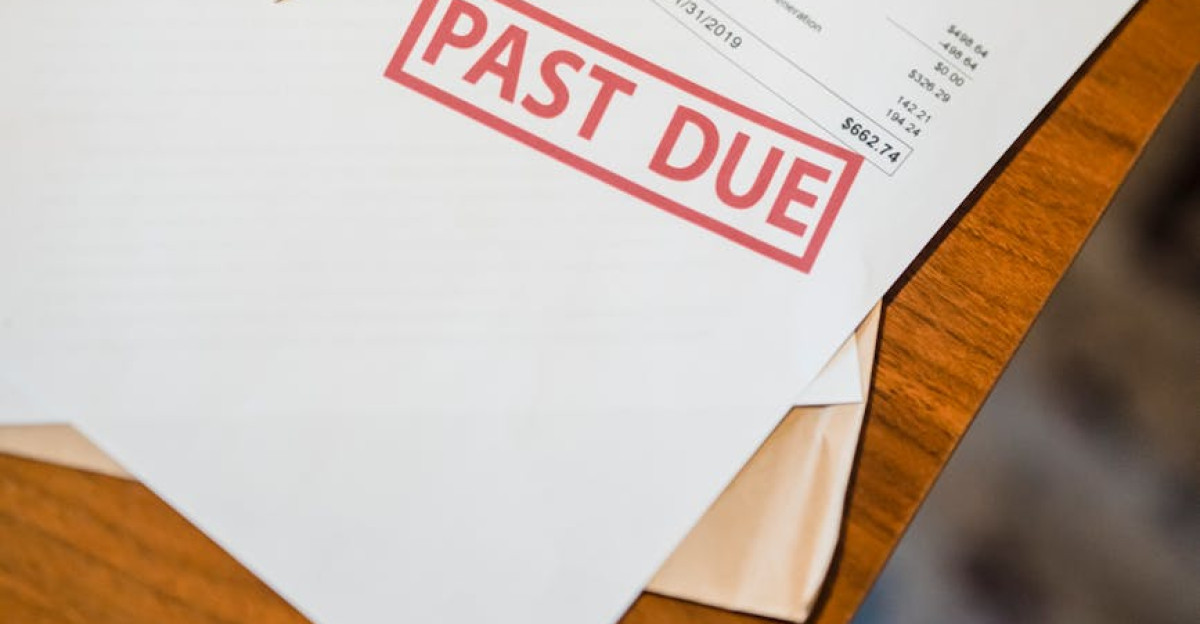 Photograph showing past due and bankruptcy documents on a wooden table