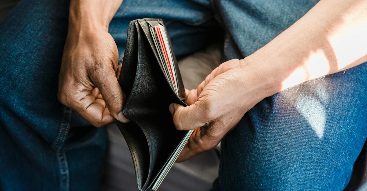 Close-up of a man holding an empty wallet symbolizing financial crisis and hardship