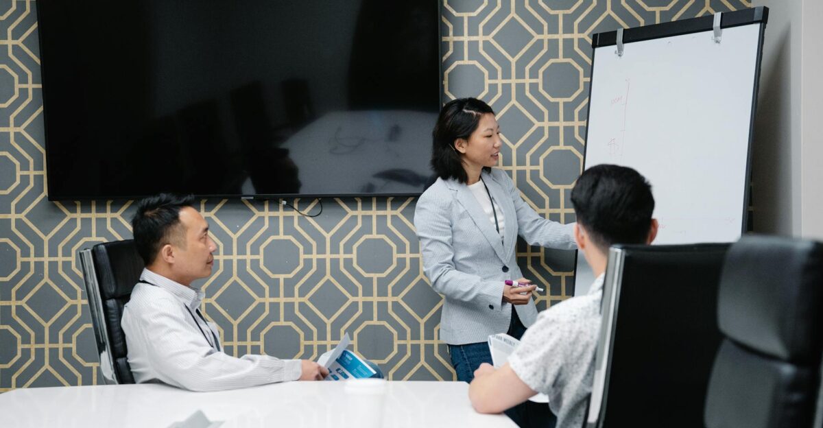 A professional conducting a presentation in a modern office space with colleagues engaged