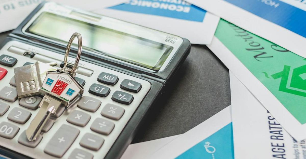 A calculator and real estate flyers depicting financial planning for home buyers