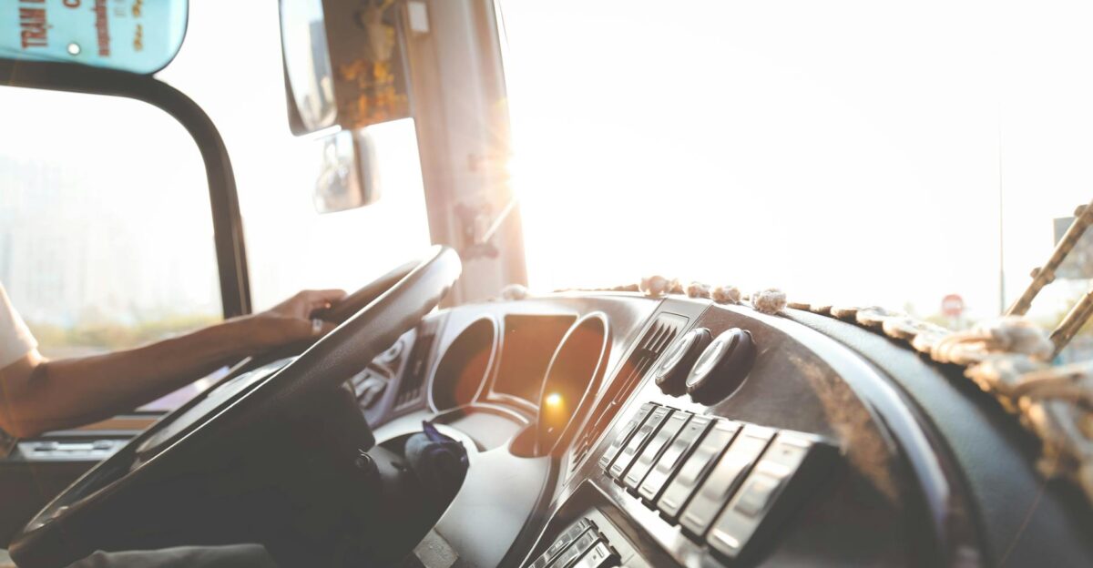 A bus driver navigating the city streets during a sunny day focusing on the road
