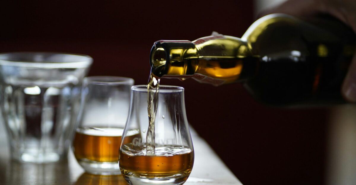 photo of person holding glass bottle