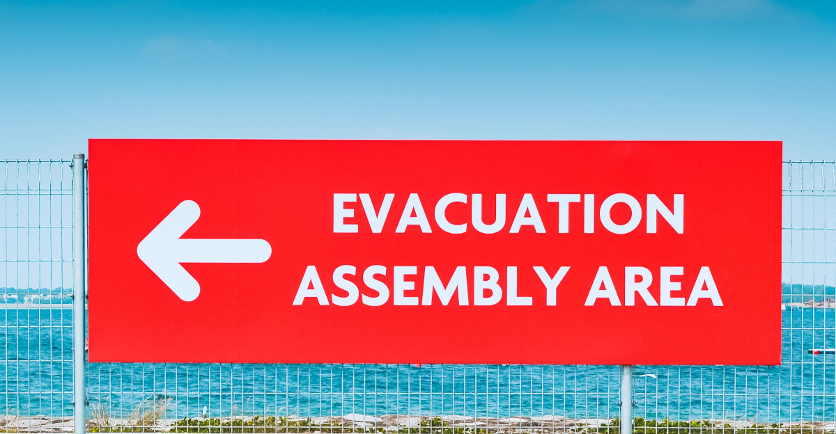 man sitting beside the road while holding an umbrella