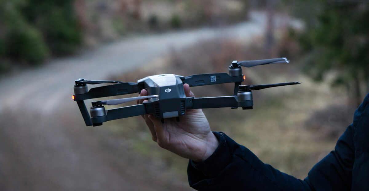 person holding black DJI drone