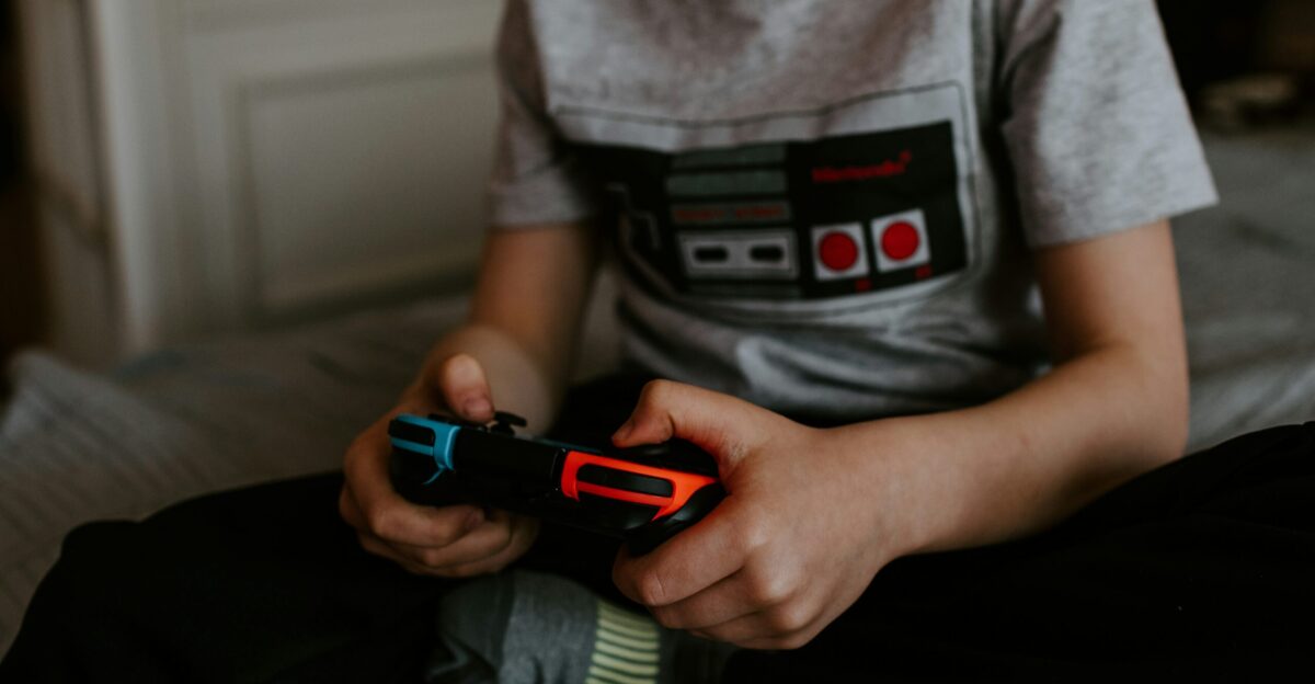 kid sitting on gray bed while playing