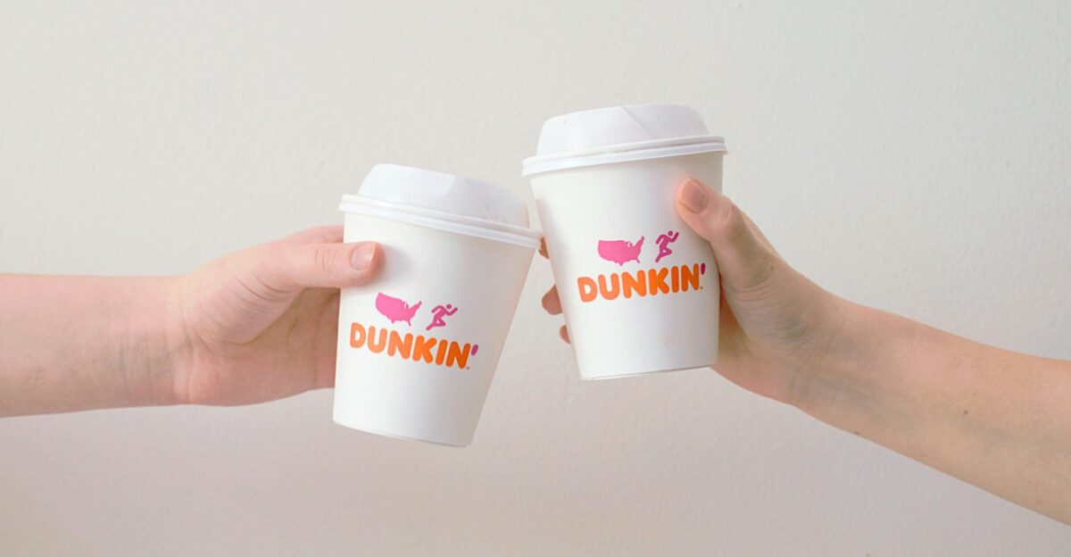 two people with white Dunkin Donuts paper cups