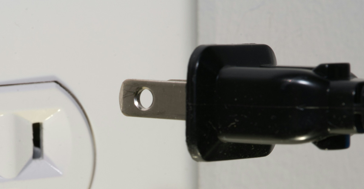 black male plug in front of electric socket