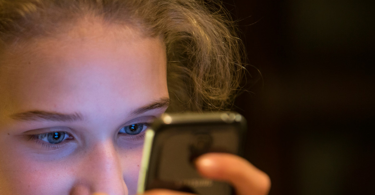 woman in gray top using smartphone
