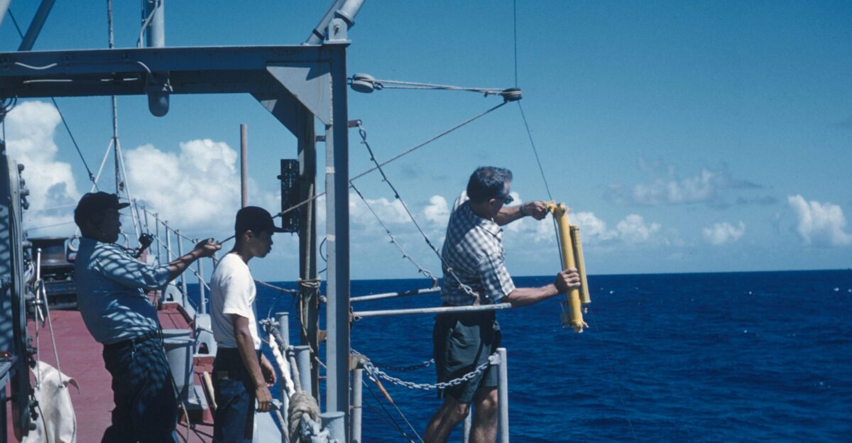 three men standing on a bridge