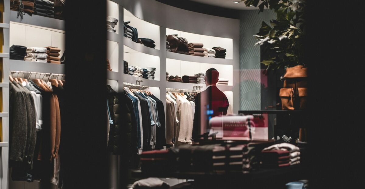 woman in red shirt standing near clothes rack