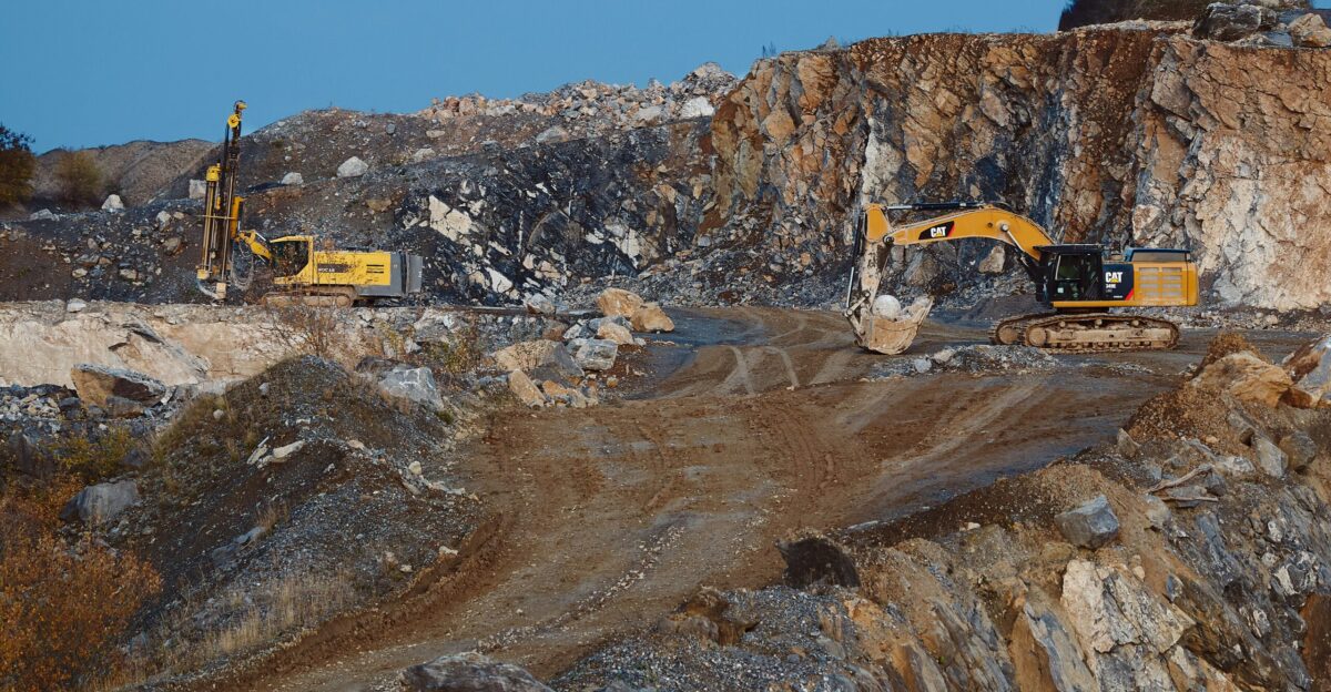 yellow and black excavator on brown rocky mountain during daytime