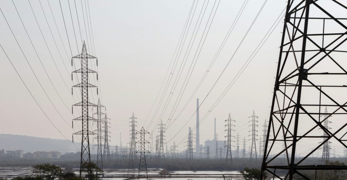 black electric towers on green grass field during daytime