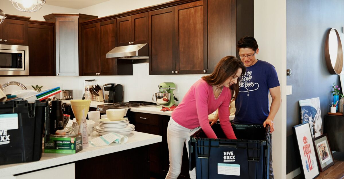 woman in pink long sleeve shirt standing beside kitchen sink