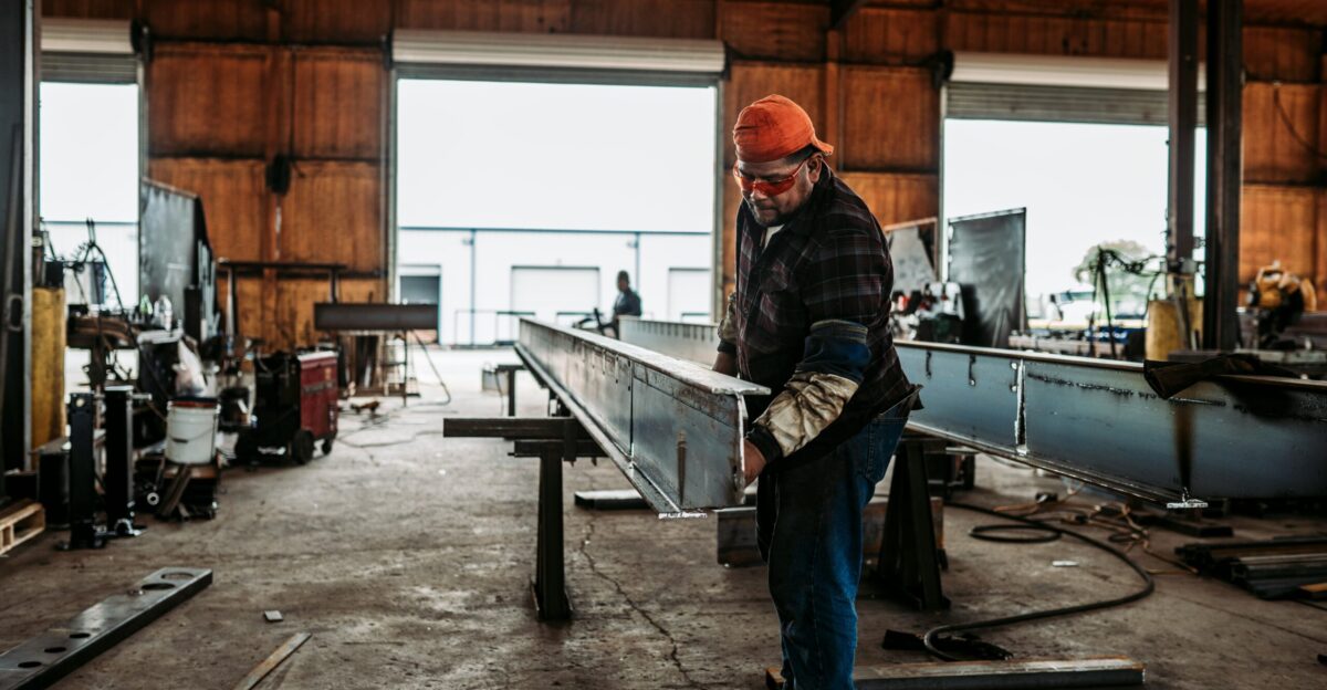 man in blue and black plaid dress shirt and red cap standing near table