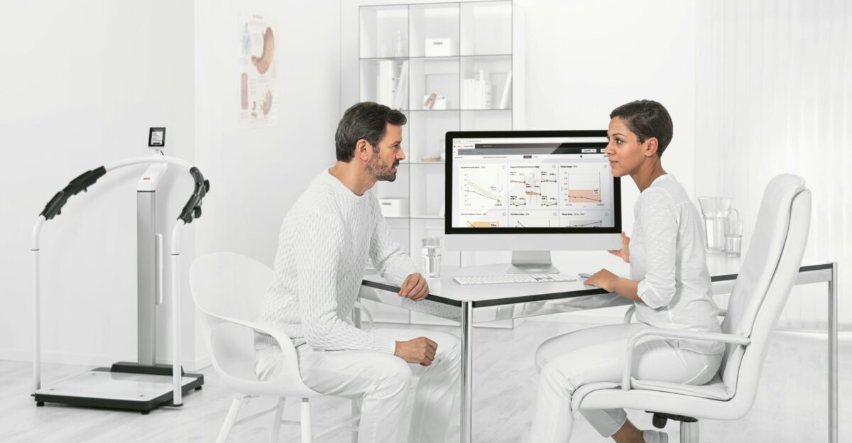 man in white dress shirt sitting on white chair in front of computer