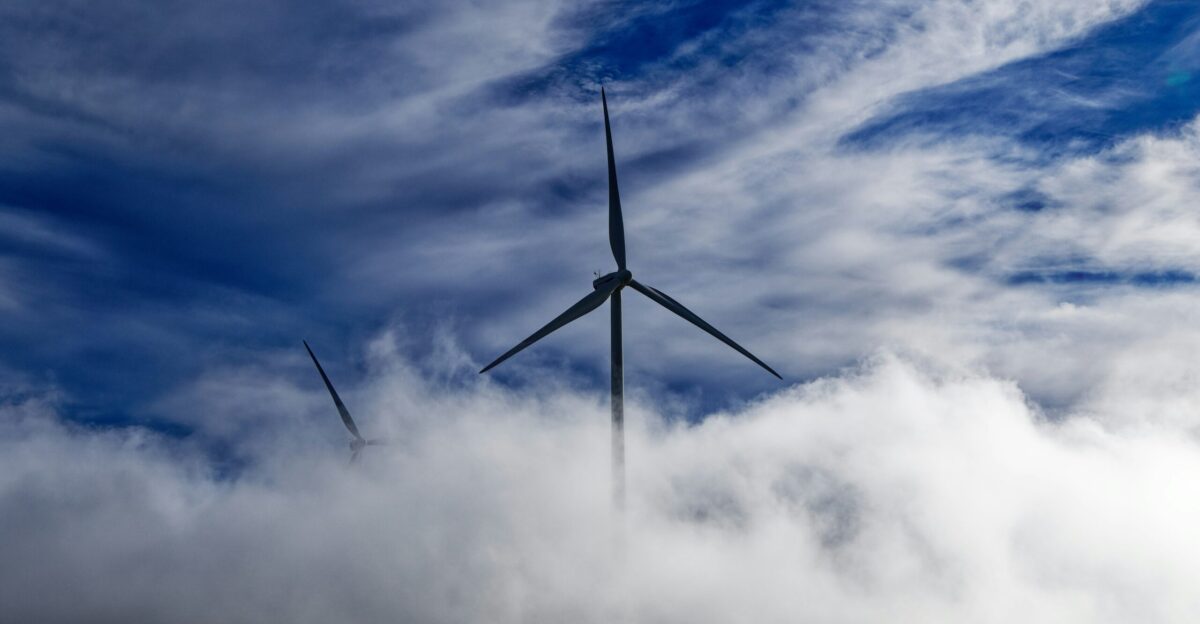 wind turbine on green grass field under white clouds