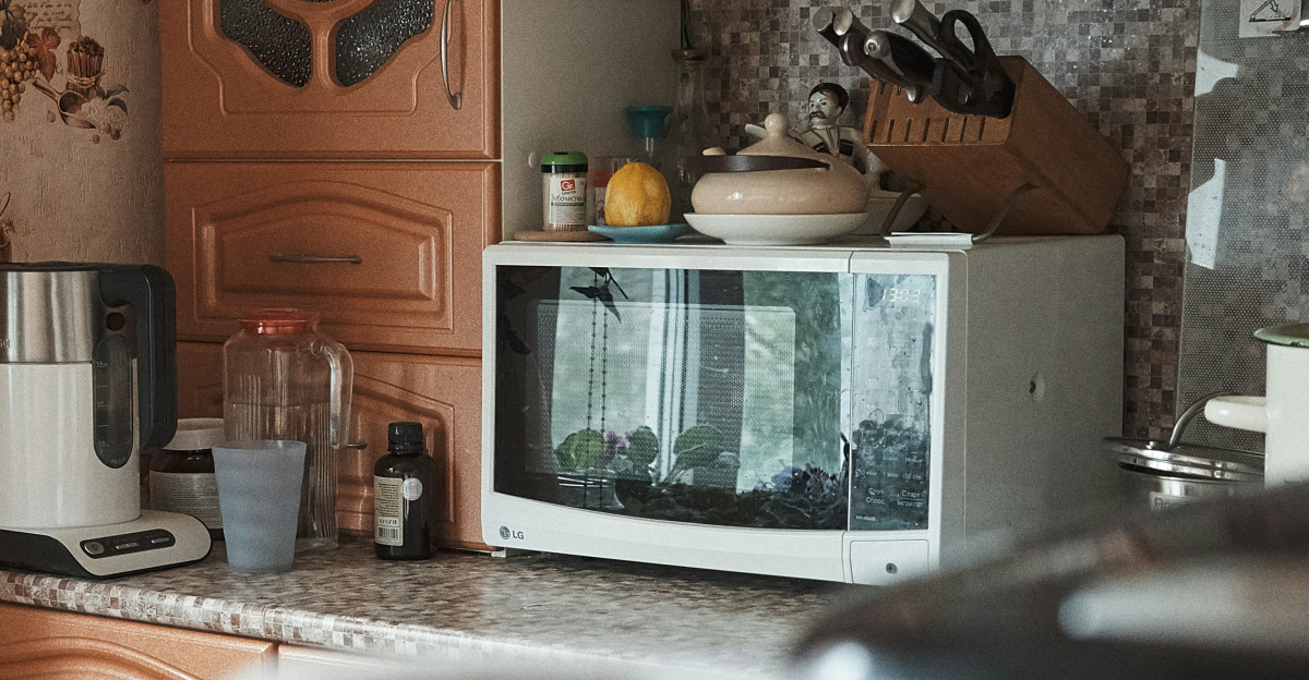 white microwave oven on brown wooden cabinet