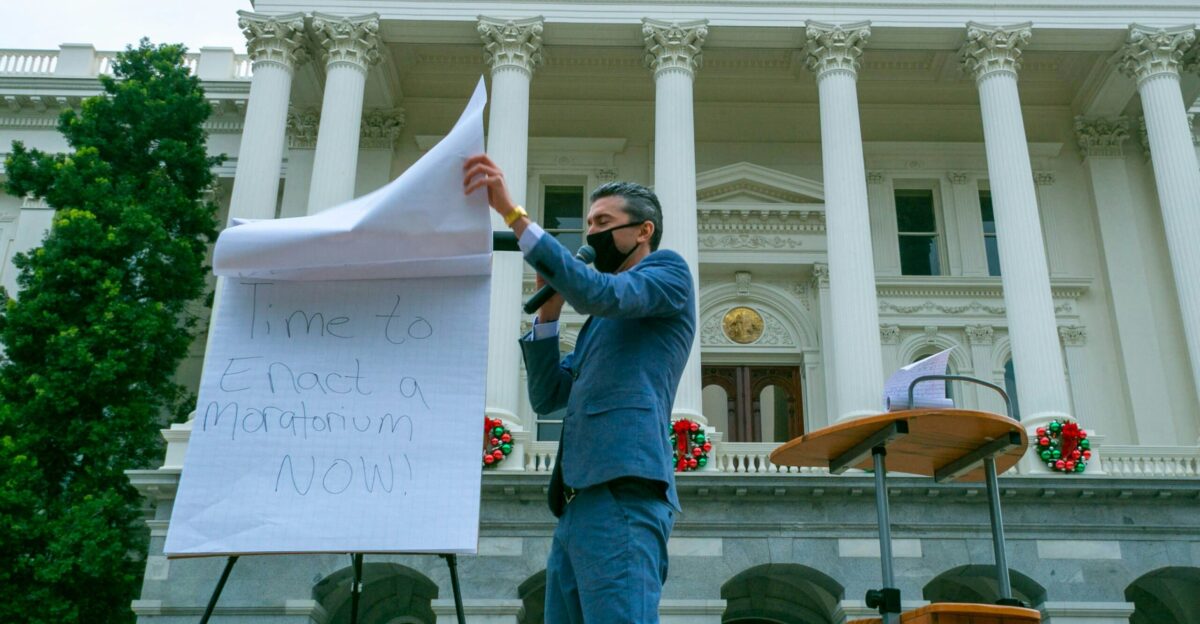 man in blue denim jacket holding white printer paper