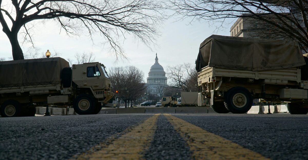 yellow truck parked near bare trees during daytime