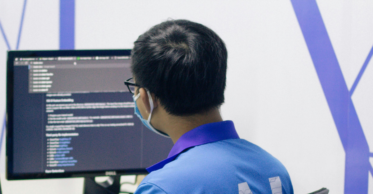 boy in blue t-shirt sitting on black office rolling chair in front of computer
