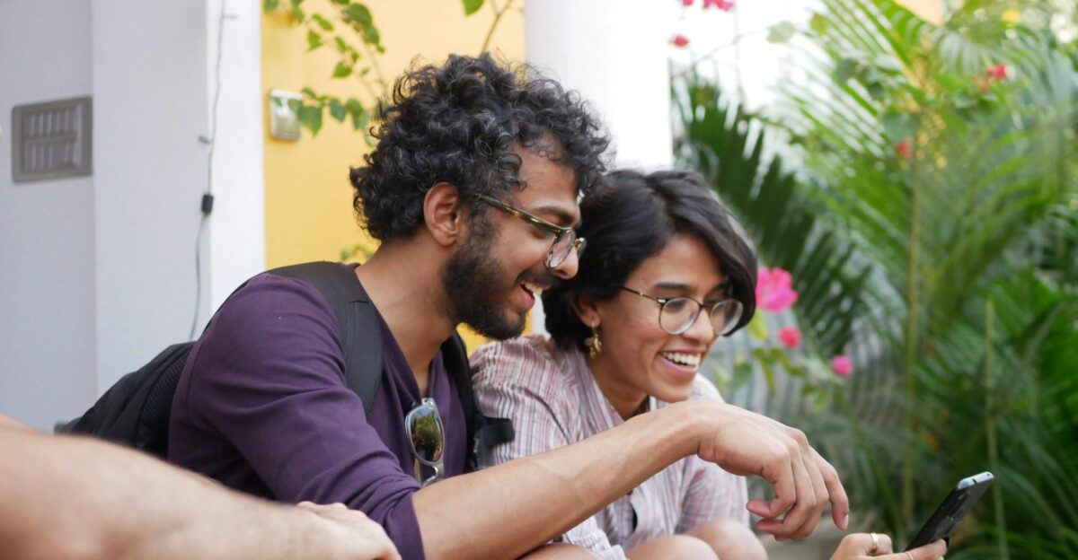 man in black polo shirt sitting beside woman in purple shirt