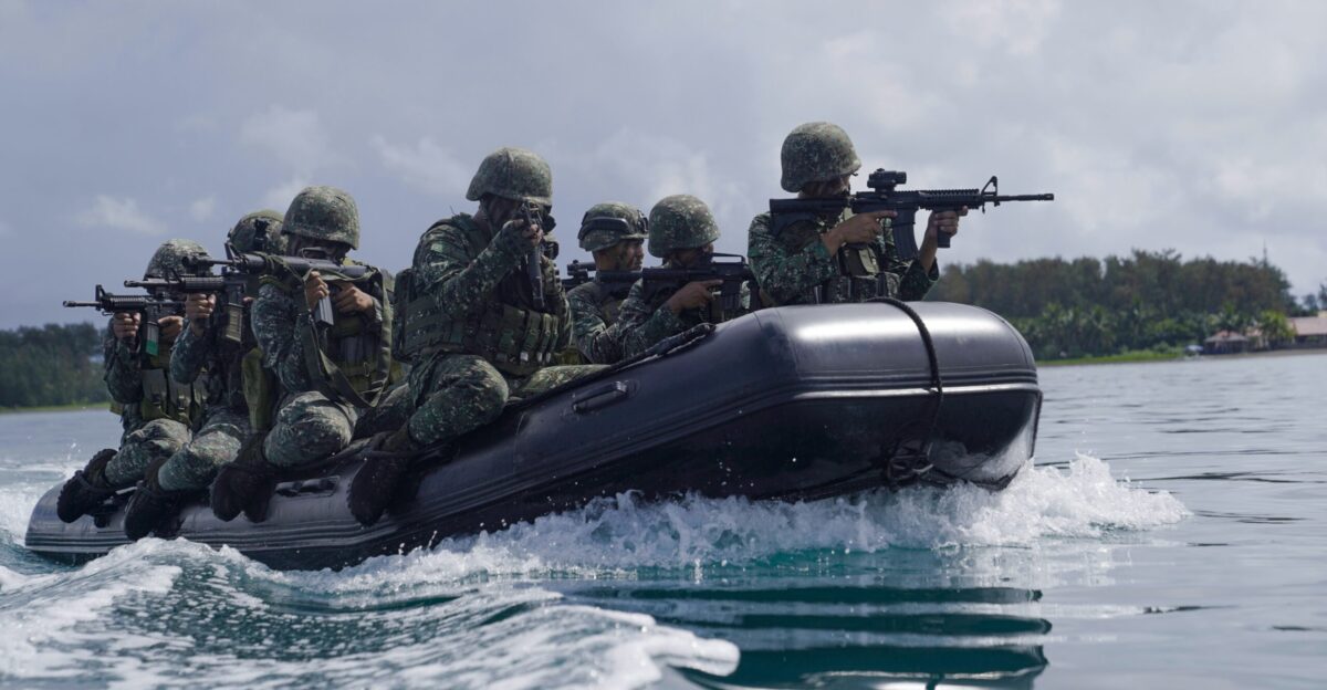 group of men in green camouflage uniform riding on black inflatable boat during daytime