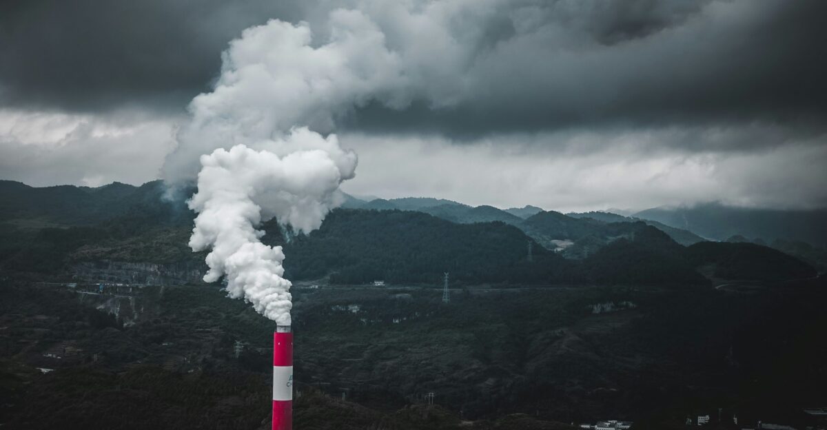 a smokestack emits from a pipe on a cloudy day