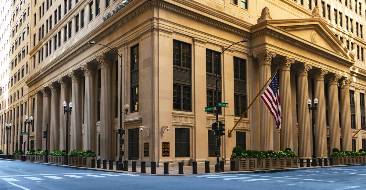 a large building with columns and a flag on the corner