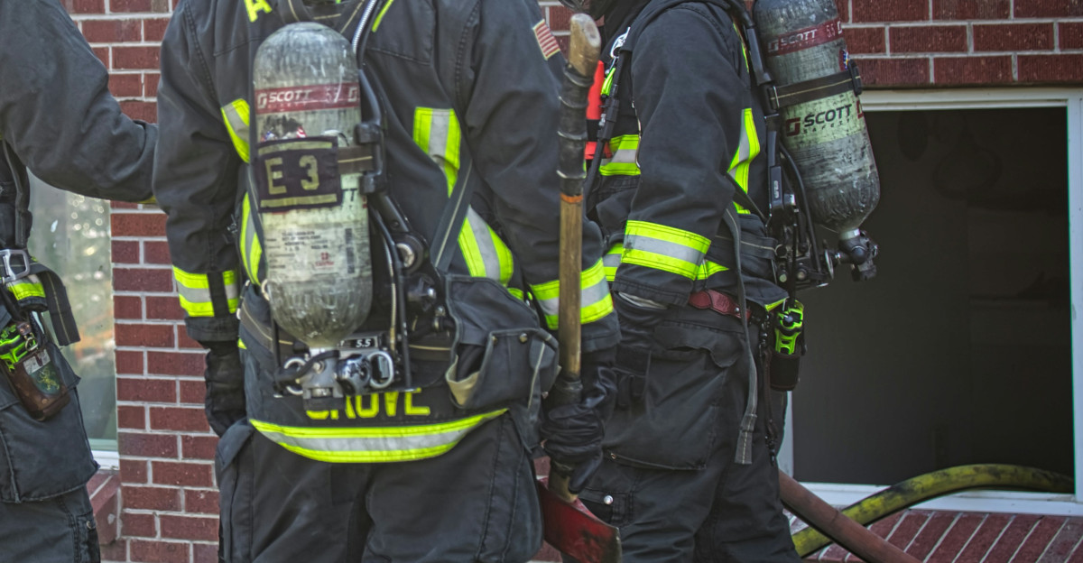 a group of firefighters standing next to a fire truck