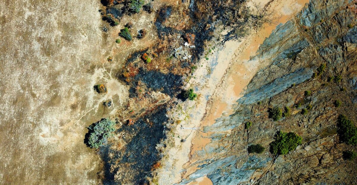 an aerial view of a sandy beach and a body of water