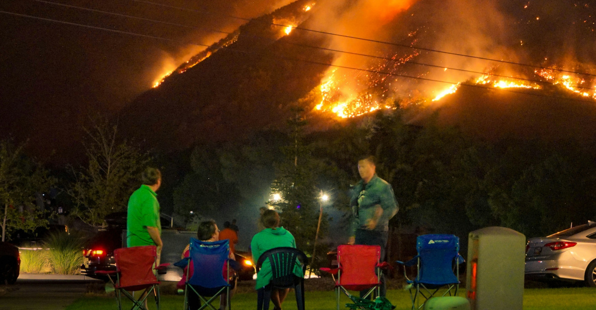 a group of people sitting in lawn chairs in front of a fire