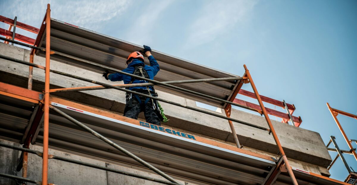 a man on a scaffold working on a building