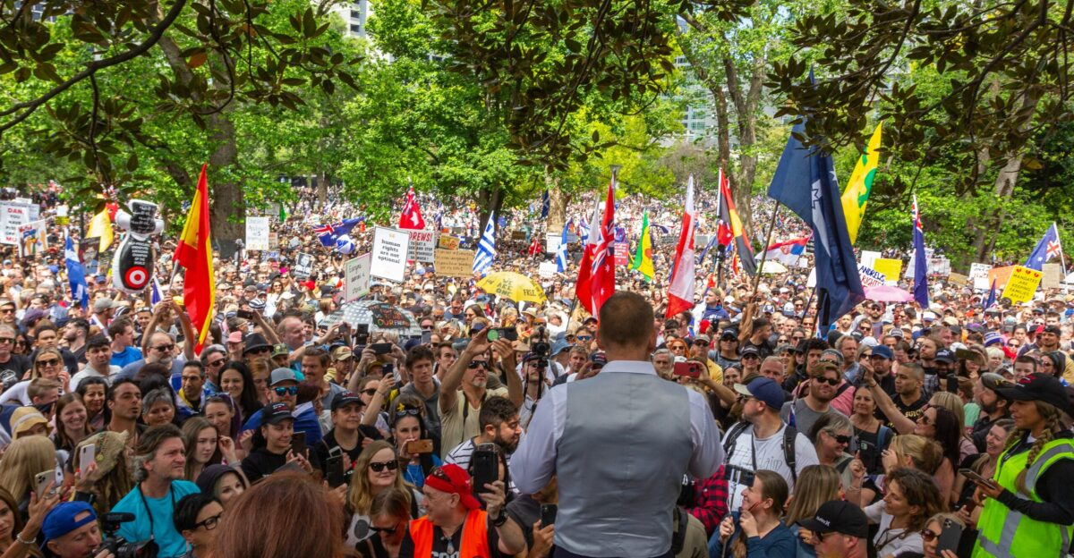 a large crowd of people standing around each other
