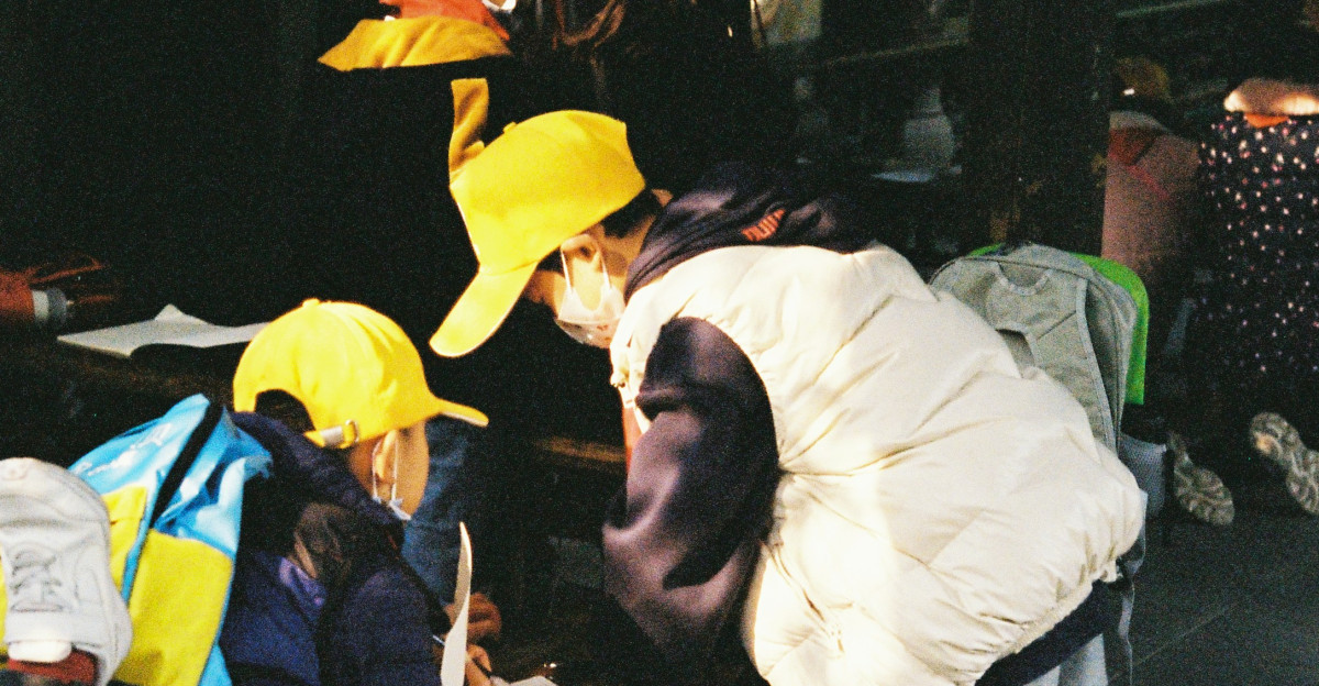 a group of people standing around a wooden bench