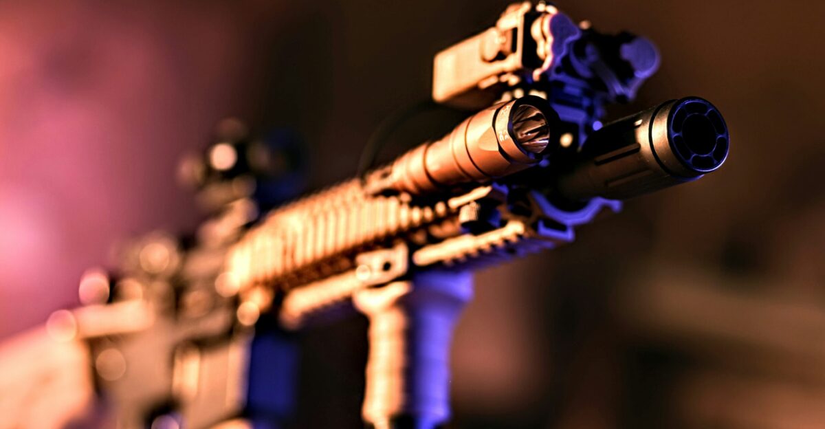a close up of a rifle with a purple light in the background