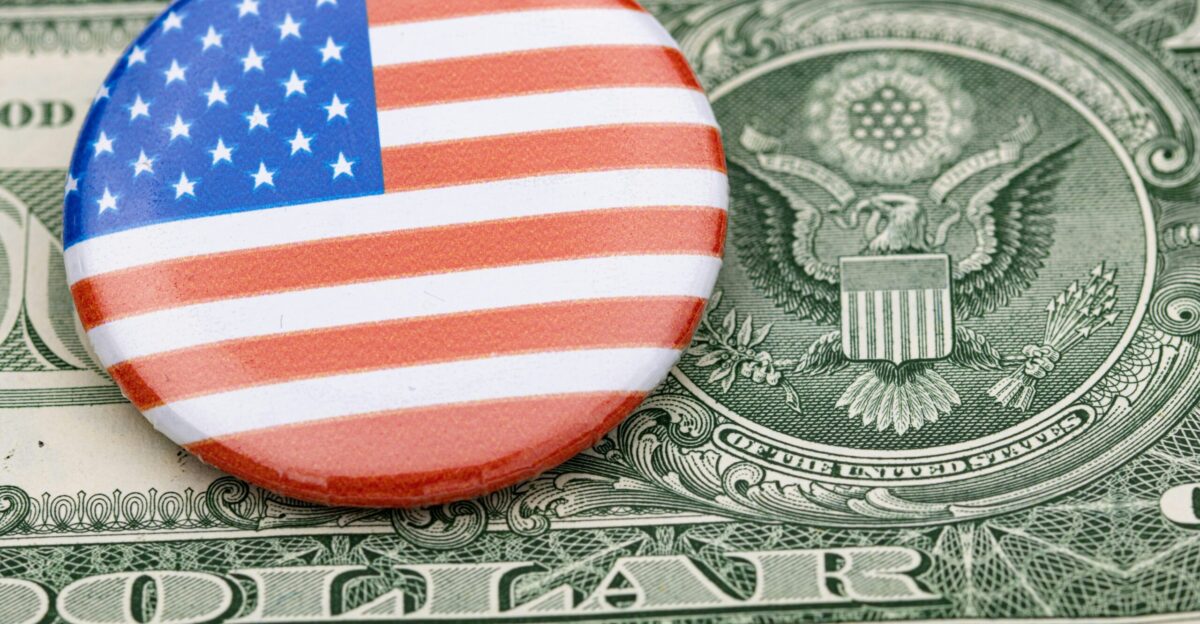 a button with the american flag on top of a dollar bill