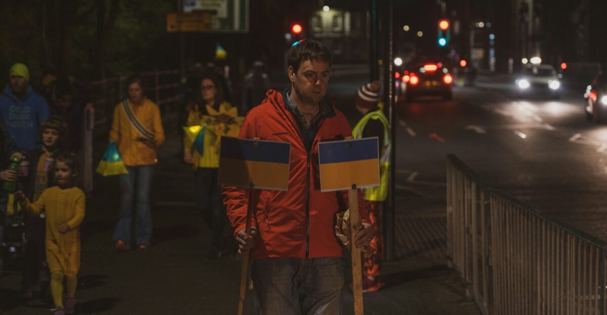 a man walking down a street holding a sign