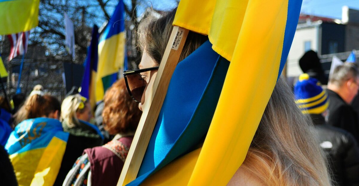 a group of people standing around each other holding flags