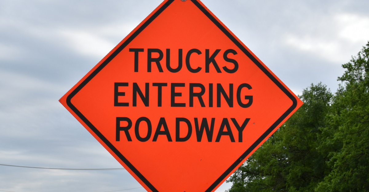 a truck entering road sign on the side of the road