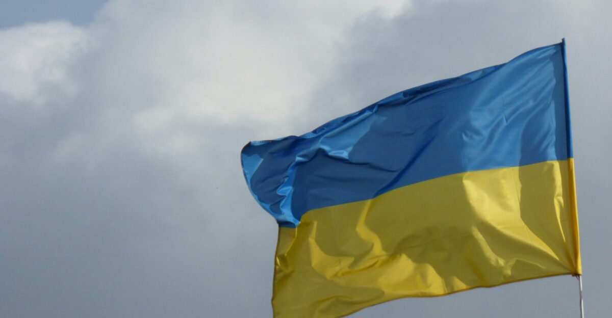 a blue and yellow flag flying in the sky