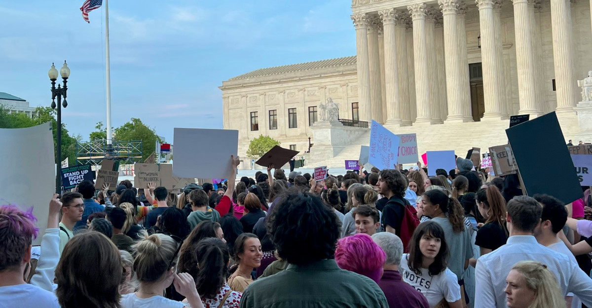 a crowd of people in front of a white building