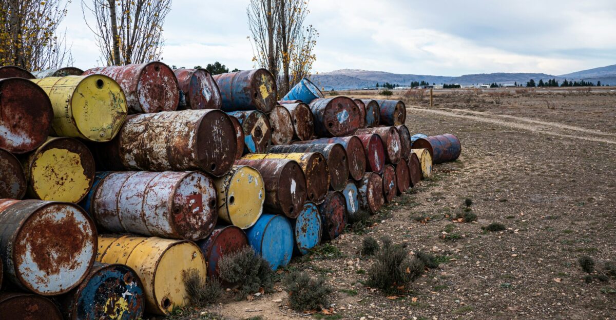 a pile of barrels sitting on top of a dry grass field